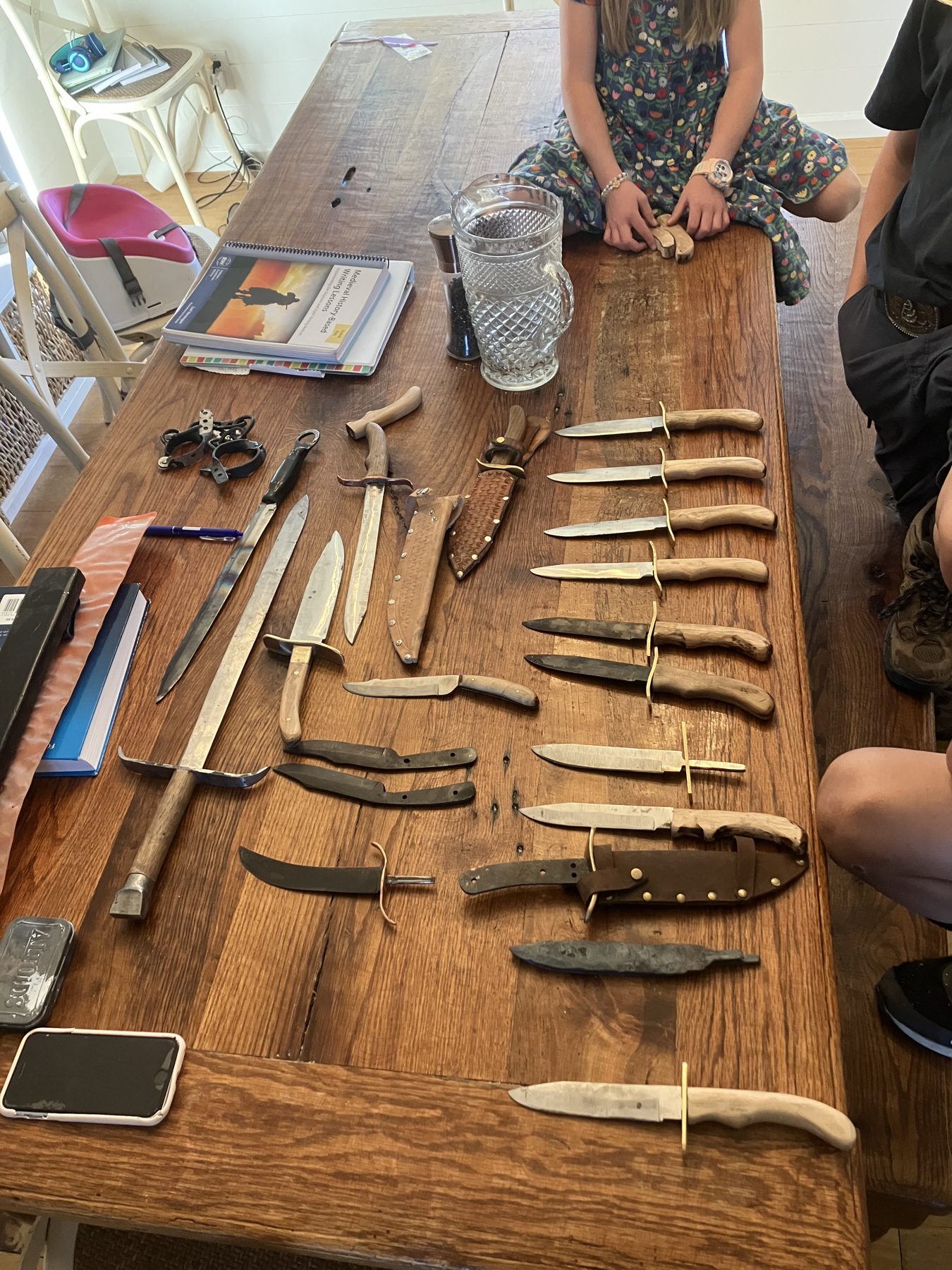 Table covered in finished knives and sheaths