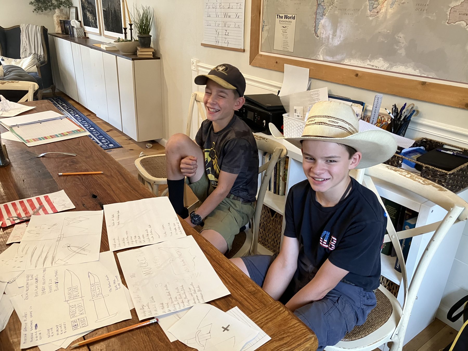 Jude and Isaac at a table covered in knife sketches